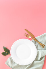 Empty tableware with tablecloth top view. Plate with fork and knife on napkin