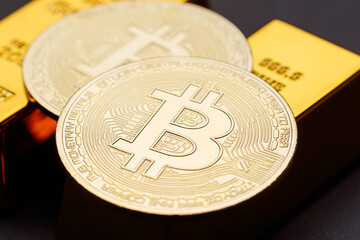 Macro photography is a Bitcoin coin lying on gold bars. The concept of the bitcoin and gold cryptocurrency financial market. Bitcoin is the coin of the future. Gold supports Bitcoin. Close-up