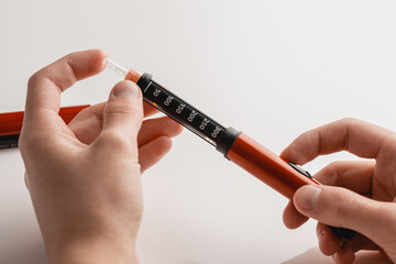 medicine, glycemia, healthcare and people concept - close-ups of man's hands. Medical devices are used for self-injection to treat diabetes. World Diabetes Day and the concept of health care