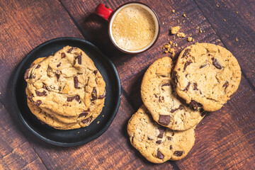 Galletas con chispas de chocolate y café sobre una mesa de madera