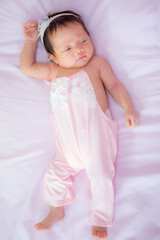 Portrait of a newborn Asian baby on the bed