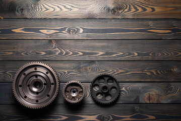 Gear wheels on the brown wooden flat lay workbench background with copy space.