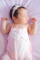 Fototapeta premium A newborn baby sleeps comfortably on a soft mattress.