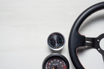 Car sport steering wheel on the white table flat lay background with copy space.