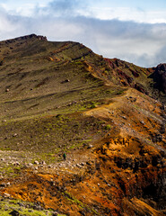 A beautiful view on mountains, sky, clouds and person figure hiking, near active volcano Aso in Kyushu, Japan