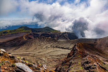 Heavy smoke bursting out from active volcano crater of Aso in the volcanic landscape in Kyushu, Japan