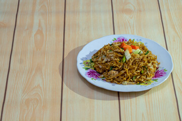 Indonesian fried noodle on wooden table