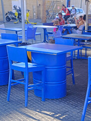 Street cafe in the port of Old Jaffa in Tel Aviv. The furniture is painted bright blue and  tables are made from old fuel barrels.