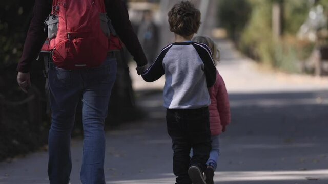 Little autistic boy walking with his family