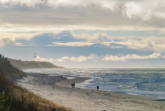 People walking on the beach coastline of Palanga on a stormy day