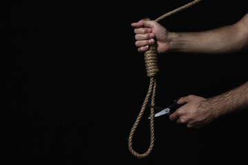 Hands cut the gallows with scissors. Solving difficult and critical situations. Helping those in...