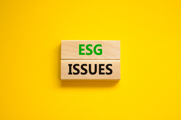 ESG environmental social governance issues symbol. Concept words ESG issues on blocks on a beautiful yellow background. Business, ESG environmental social governance issues concept. Copy space.