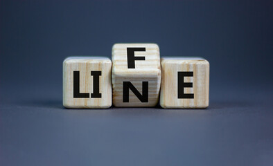 Lifeline, line of life symbol. Turned wooden cubes and changed the word 'life' to 'line'. Beautiful grey table, grey background. Business lifeline, line of life concept. Copy space.