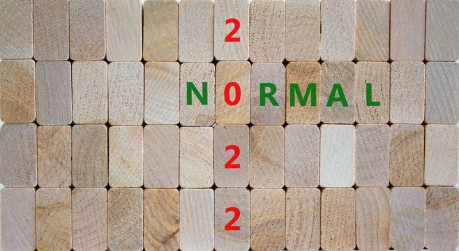 Symbol of covid-19 normal in 2022. Wooden blocks with words 'normal 2022'. Beautiful wooden background, copy space. Medical, covid-19 normal in 2022 concept.