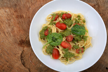 spaguetti pesto sauce with cherry tomatoes and basil