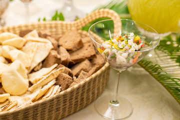 Uma cesta cheia de p&atilde;es variados em mesa de buffet.