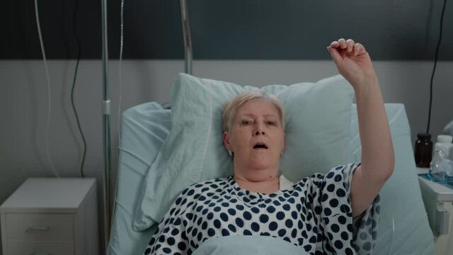 Sick patient with breathing problems asking for medical assistance in hospital ward. Senior woman hyperventilating while doctor helping with oxygen mask and nurse using stethoscope - Powered by Adobe