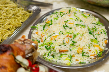 Pratos com arroz e macarrão em mesa de bufê para festa de aniversário.