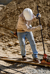 Construction worker using a rebar bender