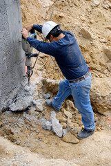 Using a jackhammer to remove excess concrete