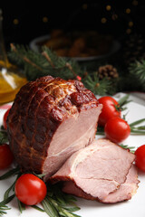 Cut delicious ham with rosemary and tomatoes on white plate
