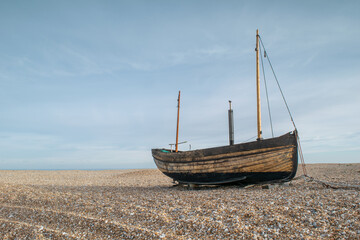 Abandoned wooden fishing boat wreck at the beach of Dungeness, Kent, England