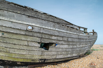 Abandoned and damaged wooden fishing boat wreck at the beach of Dungeness, Kent, England