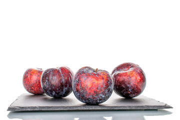 Several ripe purple plums, close-up, isolated on white.