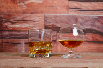 golden tequila and whiskey or brandy cognac in elegant glasses with ice