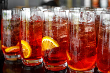 Glass of red lemonade with lemon and ice.