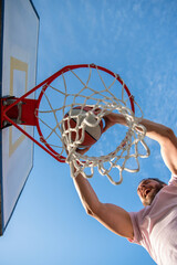 successful man with basketball ball on court. professional basketball player training outdoor. © Olena