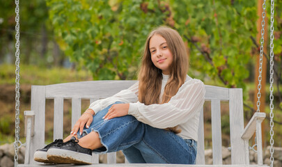 kid swinging outdoor. teen girl having fun on playground. childhood happiness. relax in park.