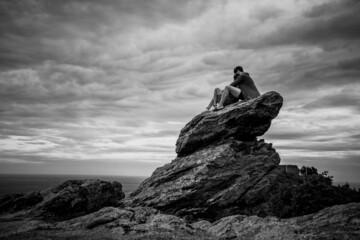 silhouette of 2 person love on the stone