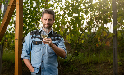 positive viticulturist man farmer drink wine at grape farm, copy space, wine-grower
