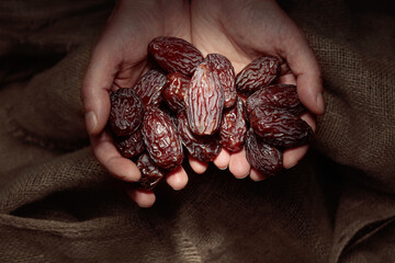 Juicy dates in hands.