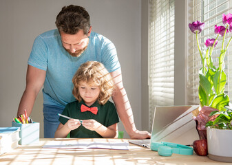 bearded daddy writing school homework with his child son in classroom, modern education