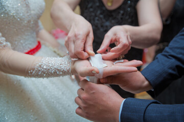 The hand of the bride is attached to the bow . The bride puts the handkerchief in her hands .