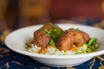 Falafel over rice in a bowl with sauce