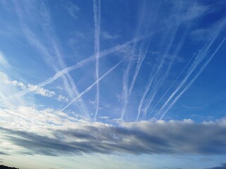 Blauer Himmel überzogen mit Kondensstreifen der Flugzeuge