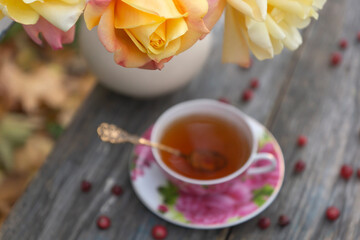 Tea in a beautiful cup and cranberry marmalade in the autumn garden.