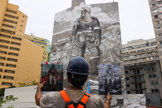 Brazilian artist and activist Mundano works on the mural 'The Forest Brigade,' in Sao Paulo