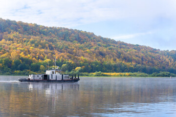 A small tugboat on the autumn river