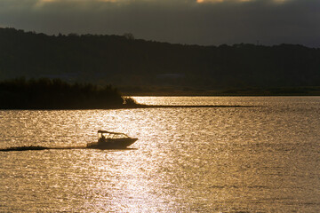 The boat sails on the evening water