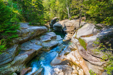 The Ammonoosuc river in a canyon among granite stones in the forest, flowing from Mount Washington in the White Mountain National Forest in New Hampshire