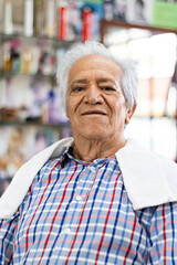 portrait of an elderly man sitting in a hairdresser's shop