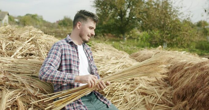 Farmer smiling and making Traditional Straw Broom with sorghum, natural broom