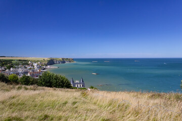 Fototapeta na wymiar view on Arromanches bay in Normandy France. Blue sky and water and visible remains of the world war mulberry harbour elements.