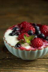 raspberries and blueberries in yogurt sauce in kremanka, top view. Juicy raspberries and blueberries. High quality photo