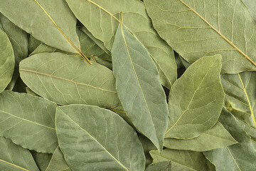 Heap of dried aromatic bay leaves as background. Dried bay leaves texture.
