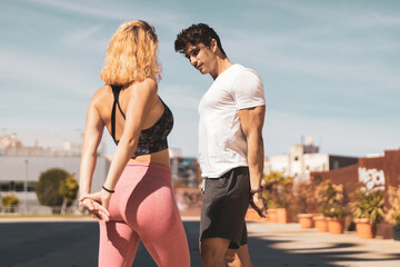 a young couple stretching in the middle of the street before exercising. 